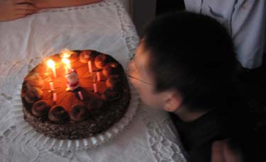 Jon blowing out candles on a chocolate cake
