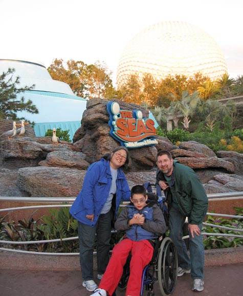Peter, Laura and Jon in front of the The Seas entrance with talking seagulls and Epcot ball behind
