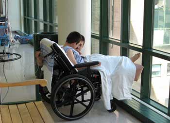 Jon on walk in a wheelchair with legs extended